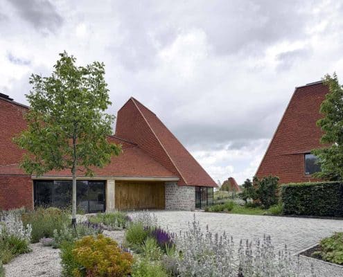 Caring Wood inner courtyard surrounded by oast style houses with handmade roof tiles in classic clay
